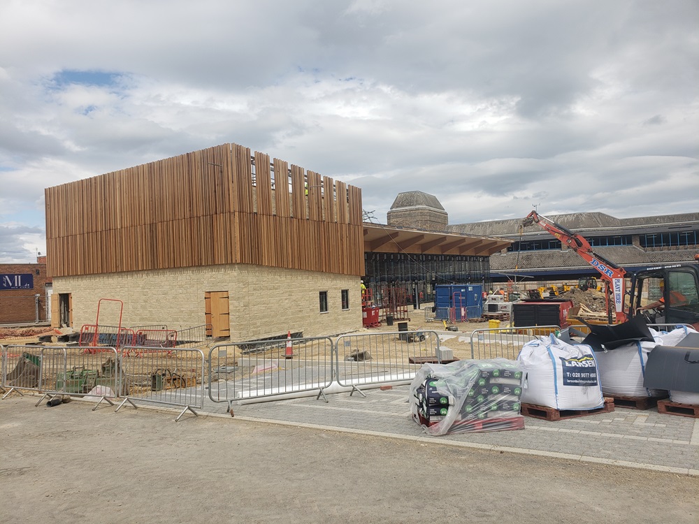 External view of works on bus station showing large wooden frame on brick base.