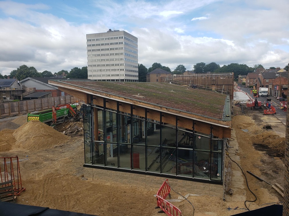 External view of the bus station. Glazing in the building from floor to ceiling and showing roof top.