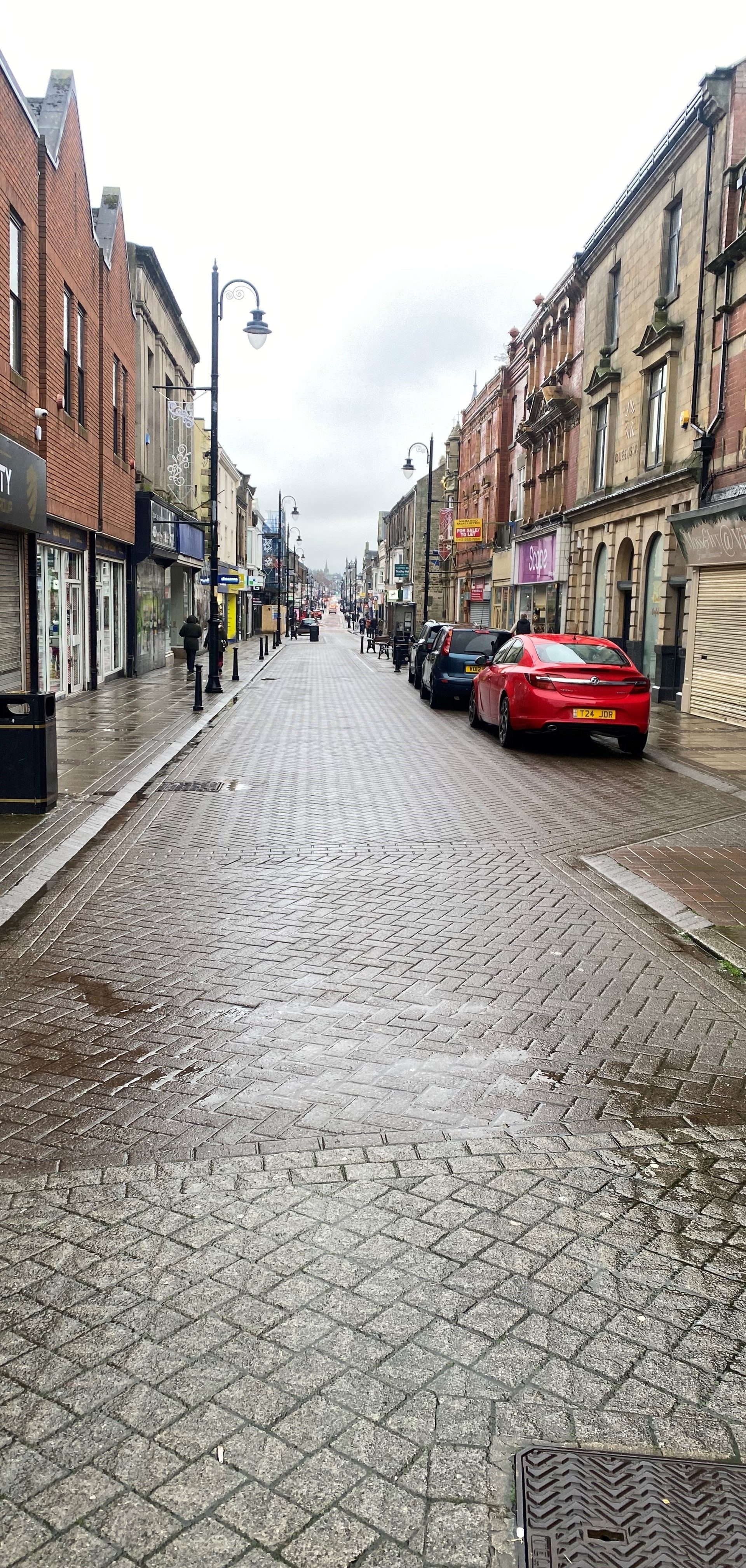 Image of North Newgate Street. Cobbled road and shop fronts running down each side