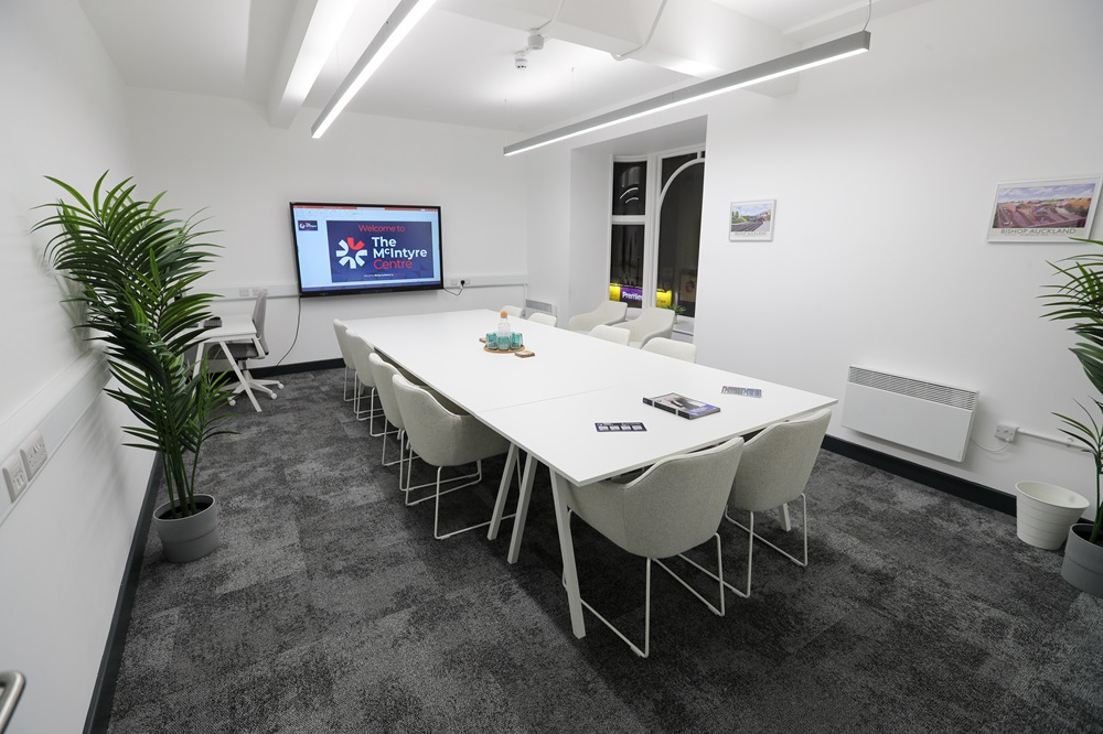 Inside the new room with large conference table and presentation equipment