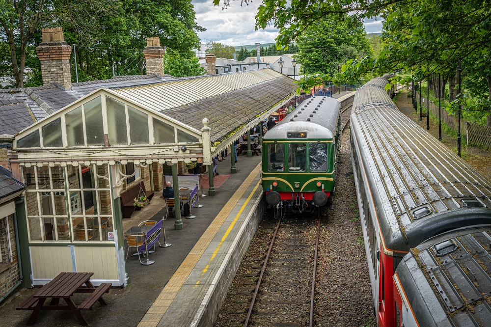 Green train pulling into station at Weardale Railway